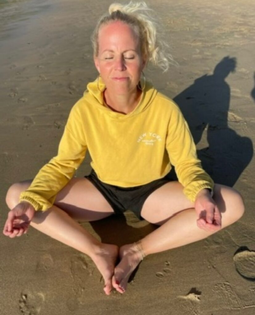 Marit i meditasjon på stranda.