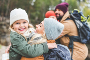 Lykkelig mamma holder sin smilende datter i armene.