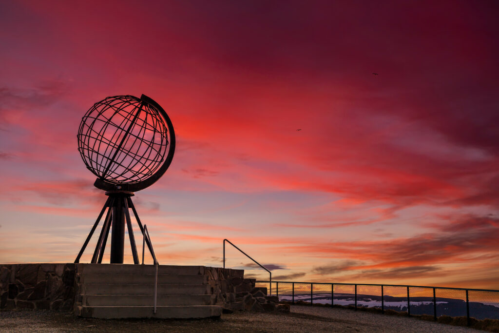 Nordkapp i solnedgang, med rødoransje himmel. Og silhuetten av nordkapp.