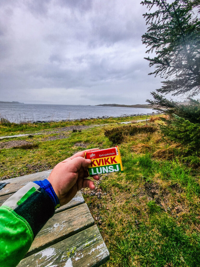 Magnar holder en kvikklunsj med naturlandskapet i bakgrunn.