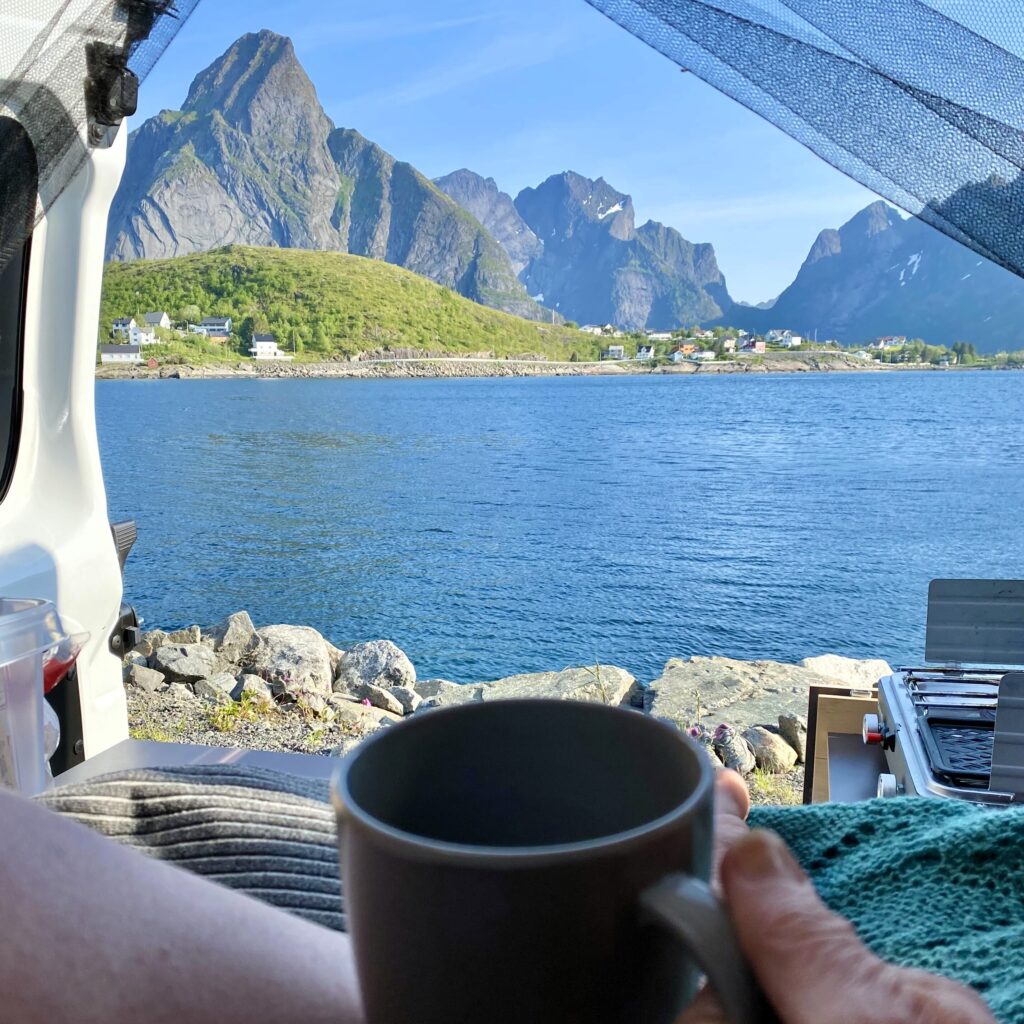 Kaffekoppen i campingbilen med utsikt mot Reine i Lofoten.