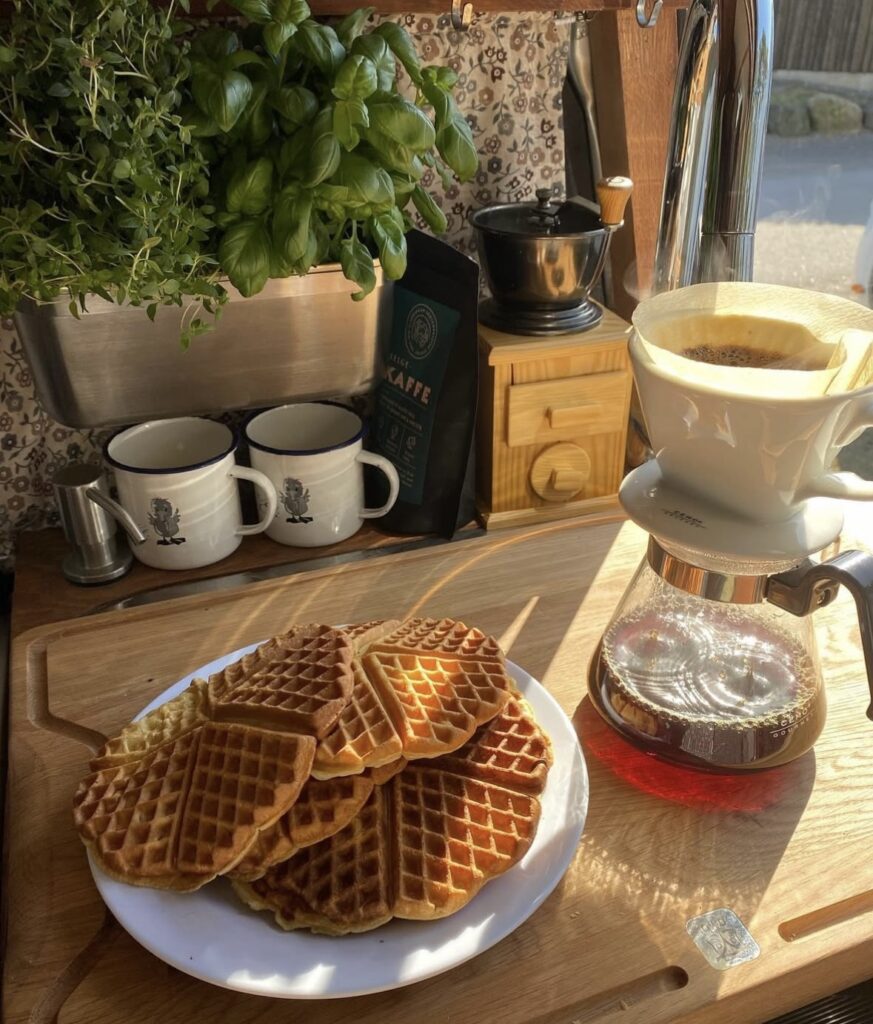 Rustiskt frokostbord med vafler og kaffe.