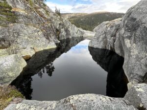 Jettegrytene i kvitingen. Mørkt vann omgitt av fjell.