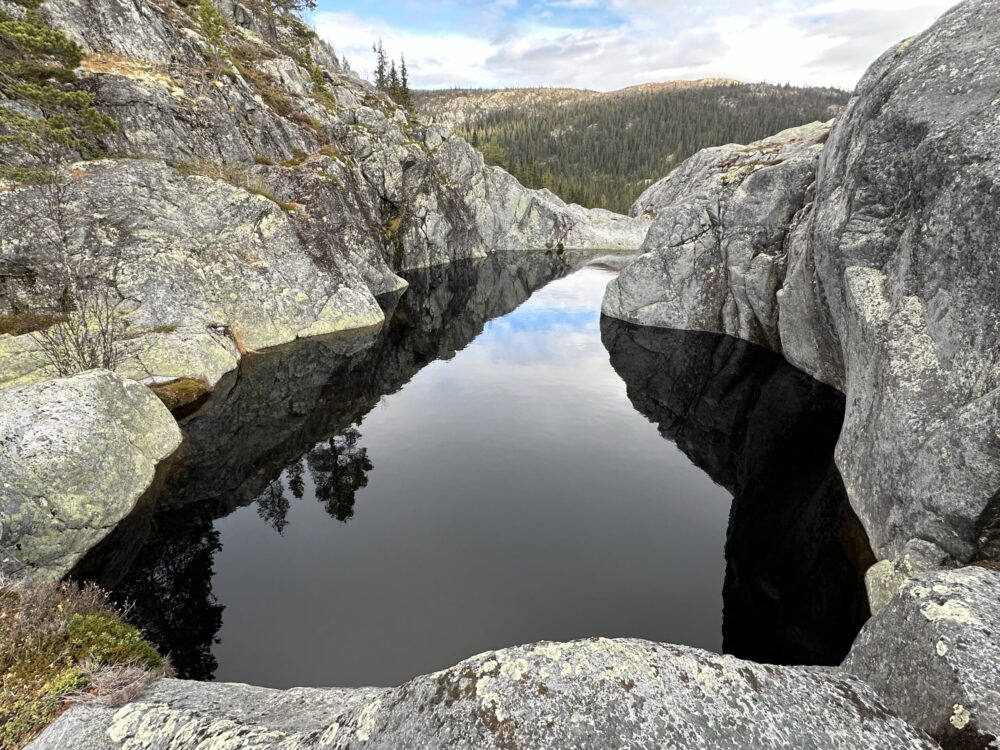Jettegrytene i kvitingen. Mørkt vann omgitt av fjell.