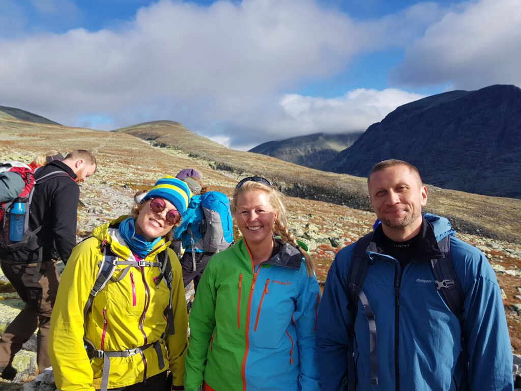 Glade turgåere i turklær i fjellheimen. I strålende sol og lett overskyet himmel.