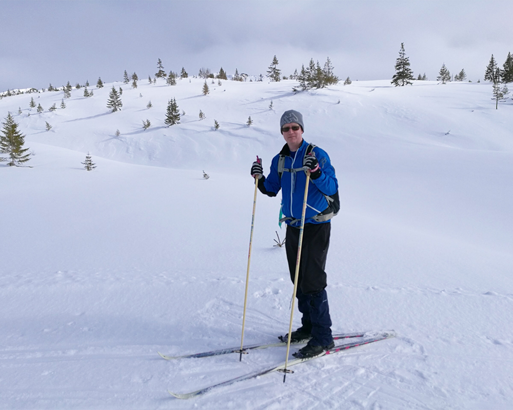 Tomas på ski i et snøkledd landskap.